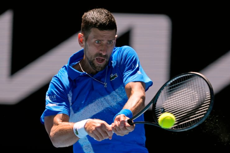 Novak Djokovic mentre esegue un rovescio bimane
