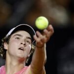 Primo piano di Joao Fonseca mentre lancia la pallina per servire