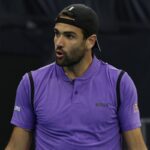 Matteo Berrettini con una maglia viola e uno sguardo sorpreso