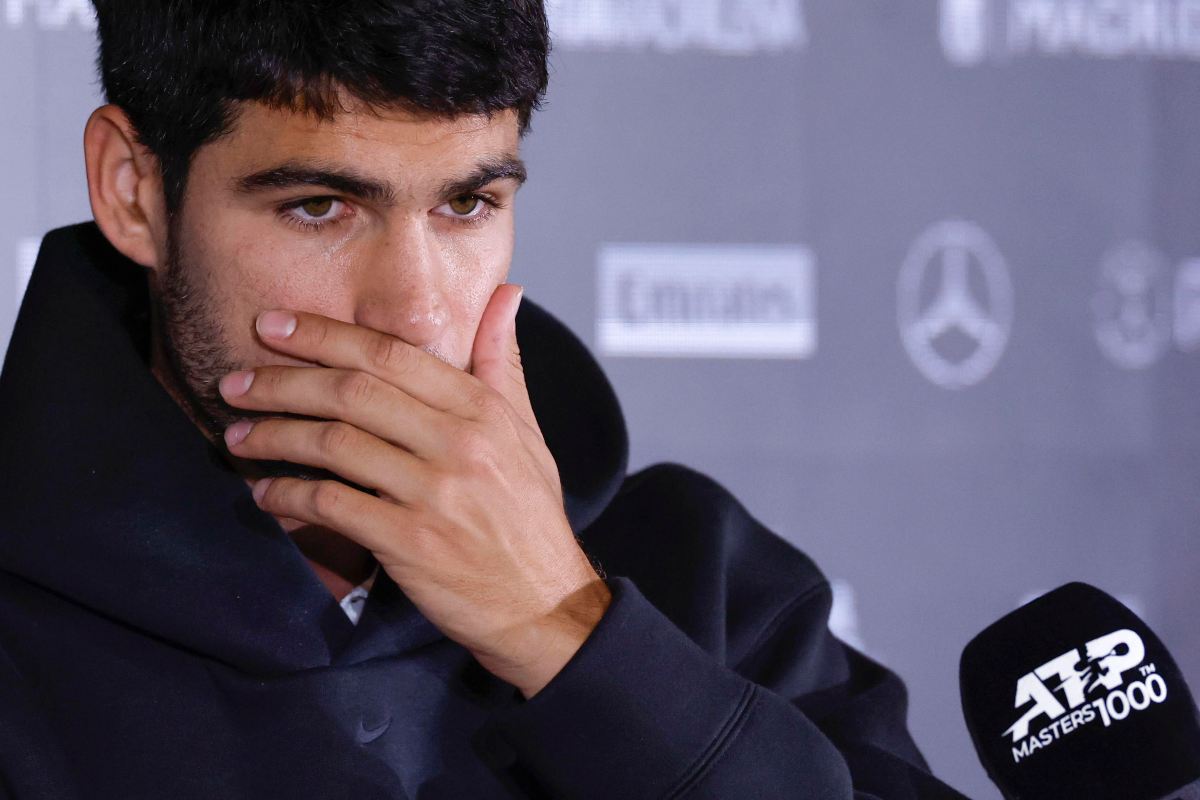 Carlos Alcaraz si porta la mano alla bocca in conferenza stampa