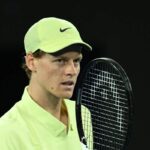 Jannik Sinner concentrato con una racchetta davanti al naso