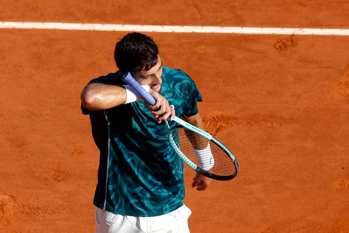 Lorenzo Musetti si asciuga il sudore in campo a Montecarlo