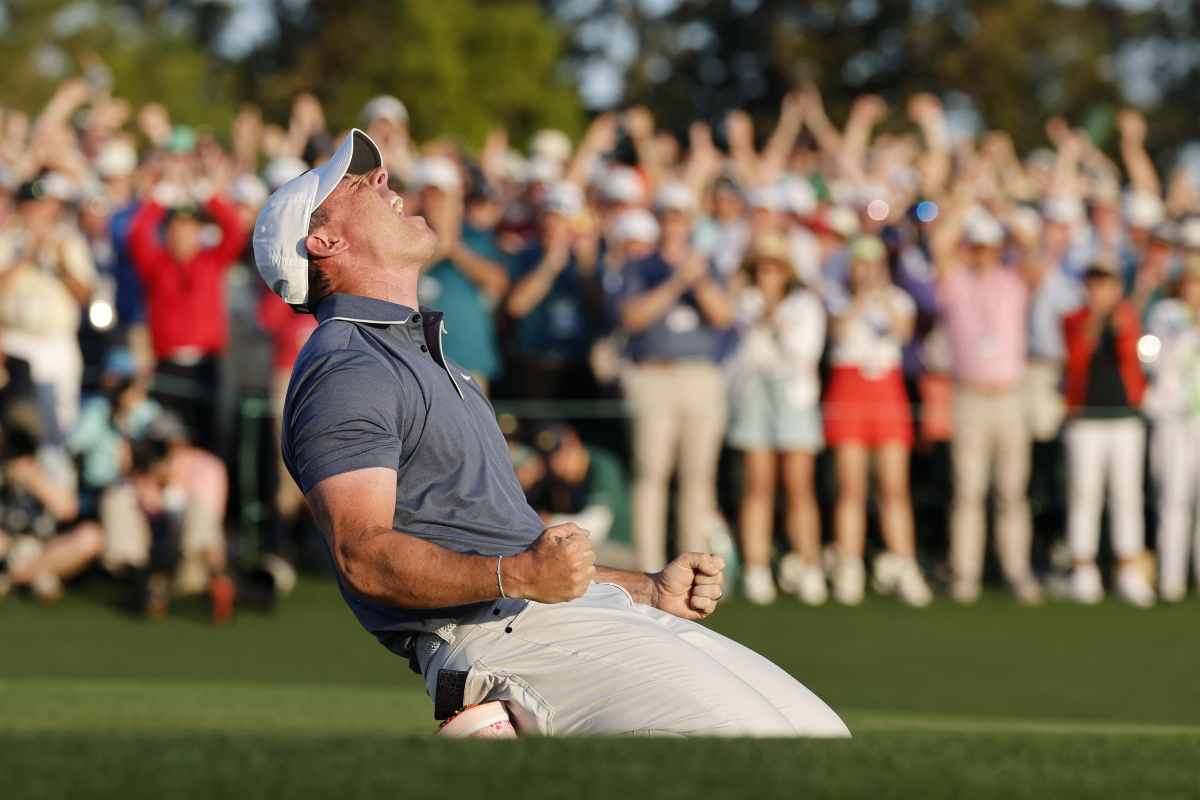 Il golfista Rory McIlroy esulta inginocchiato dopo una vittoria