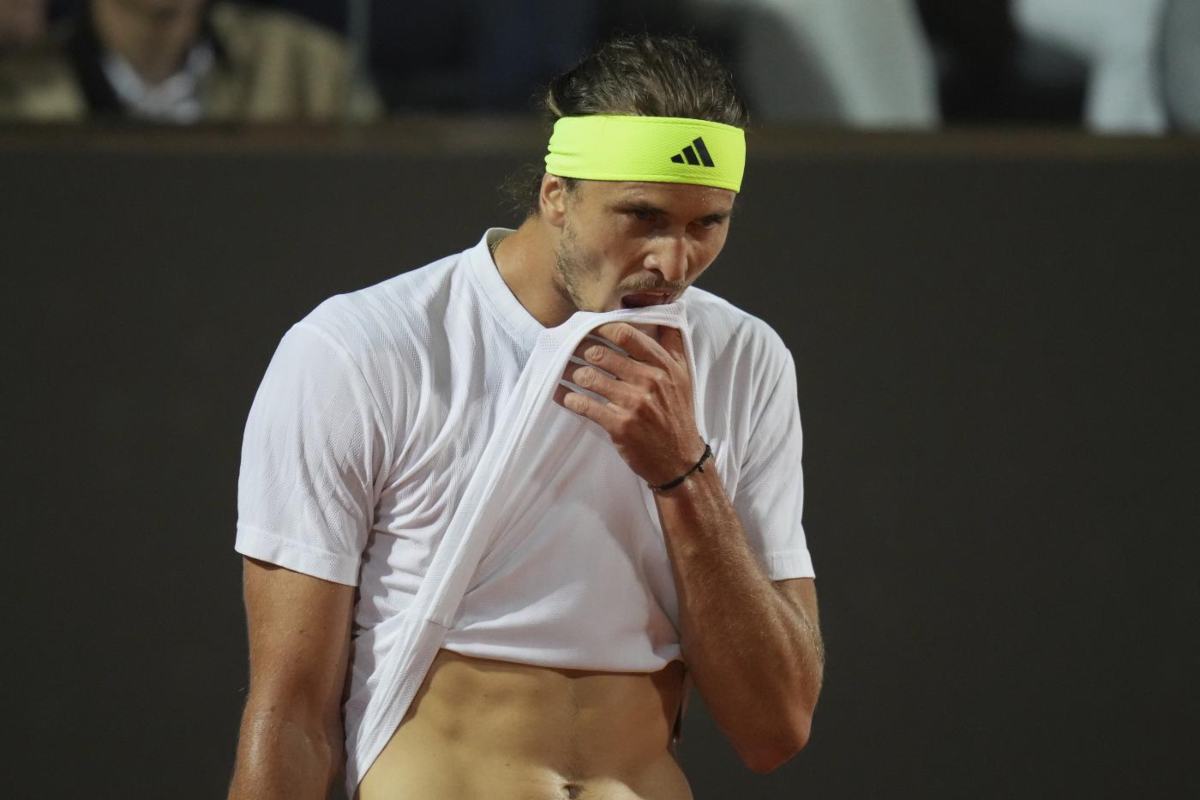 Alexander Zverev mentre si copre il mento con un lembo della maglietta