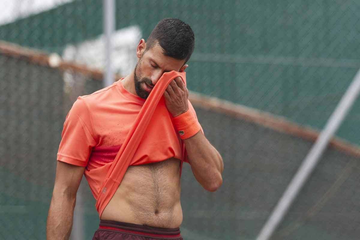 Novak Djokovic si porta la maglia sul viso durante un match