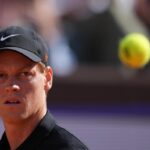 Jannik Sinner mentre fissa di traverso la pallina sospesa in aria