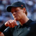 Jannik Sinner si porta il dorso della mano verso la bocca