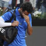 Matteo Berrettini a capo chino e con una mano davanti agli occhi