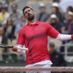 Novak Djokovic con la testa reclinata all'indietro e con le braccia allargate