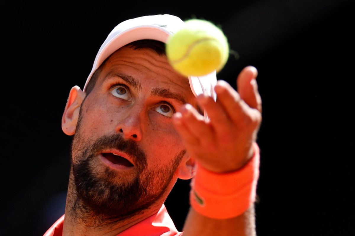 Primo piano di Novak Djokovic, che si appresa alla battuta lanciando la pallina