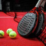 Palline e racchette da padel vicino la rete