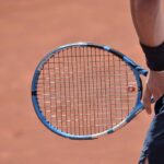 Una racchetta da tennis tenuta in mano da un giocatore