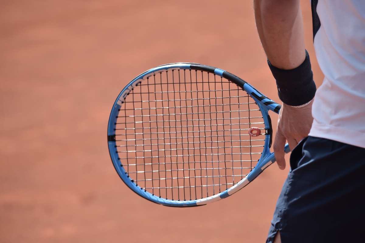 Una racchetta da tennis tenuta in mano da un giocatore