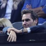 Roger Federer seduto in tribuna e con le mani appoggiate sul parapetto