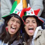 Due tifose italiane che indossano sorridenti un cappello tricolore
