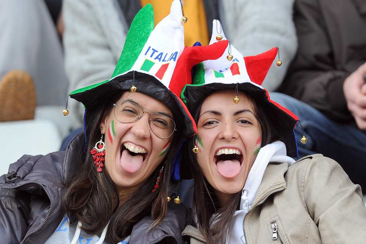 Due tifose italiane che indossano sorridenti un cappello tricolore