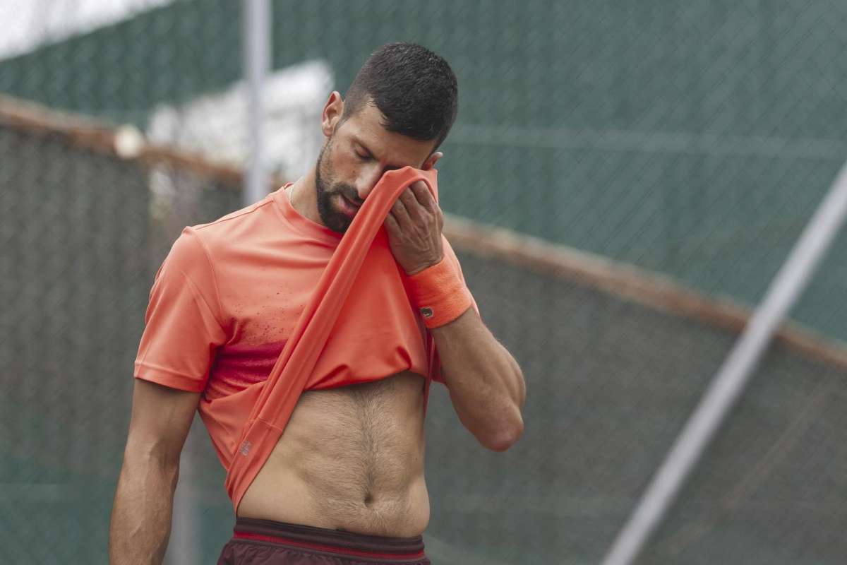 Novak Djokovic si copre il volto con la maglia