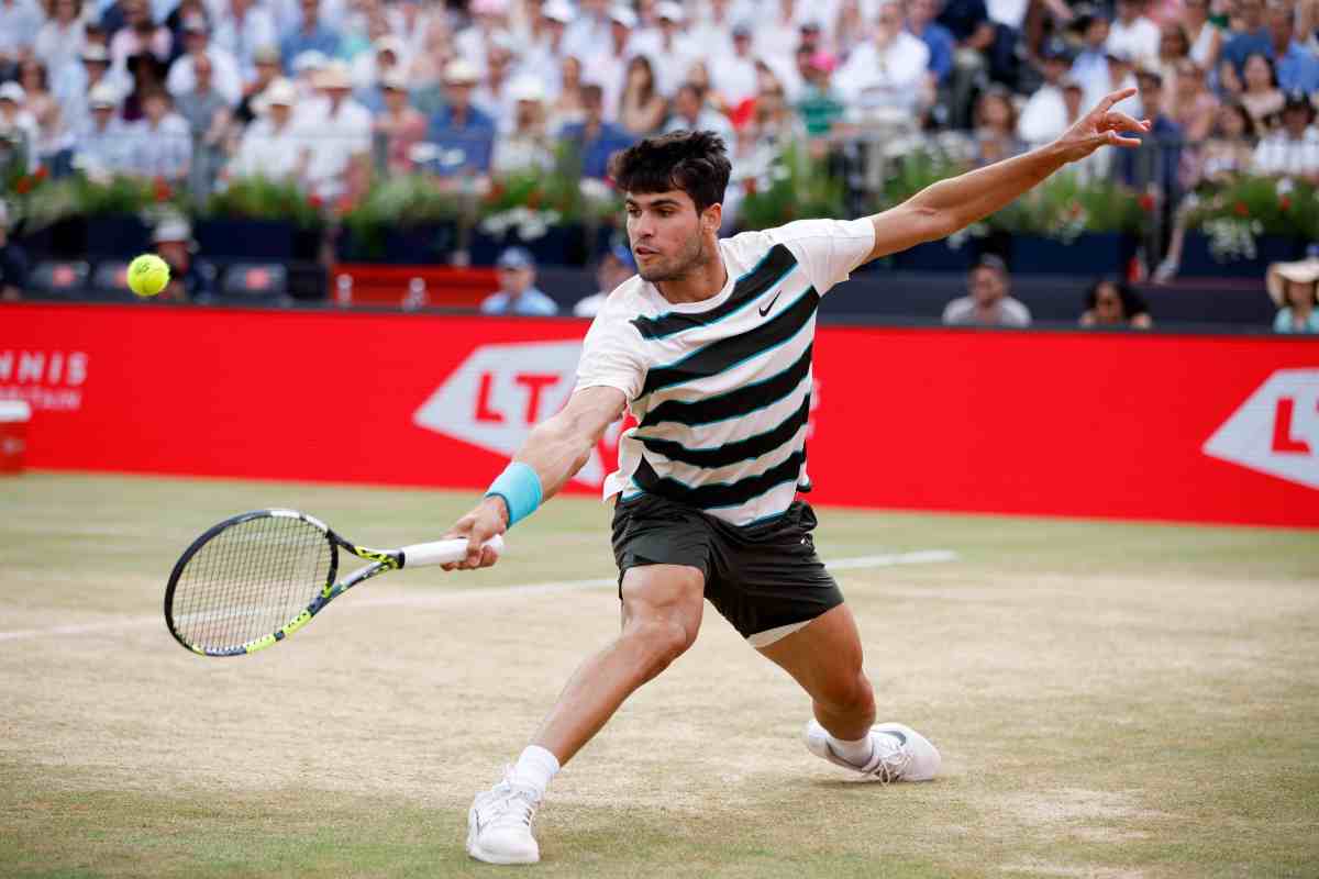 Carlos Alcaraz in azione con il rovescio sull'erba del Queen's