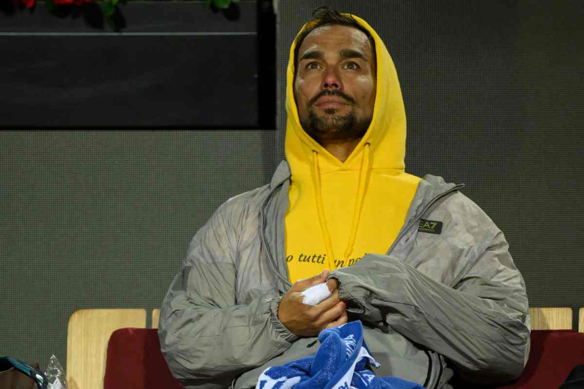 Fabio Fognini seduto in panchina con felpa e cappuccio guarda nel vuoto