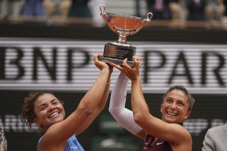 Jasmine Paolini e Sara Errani, sorridenti, alzano al cielo il trofeo vinto a Parigi