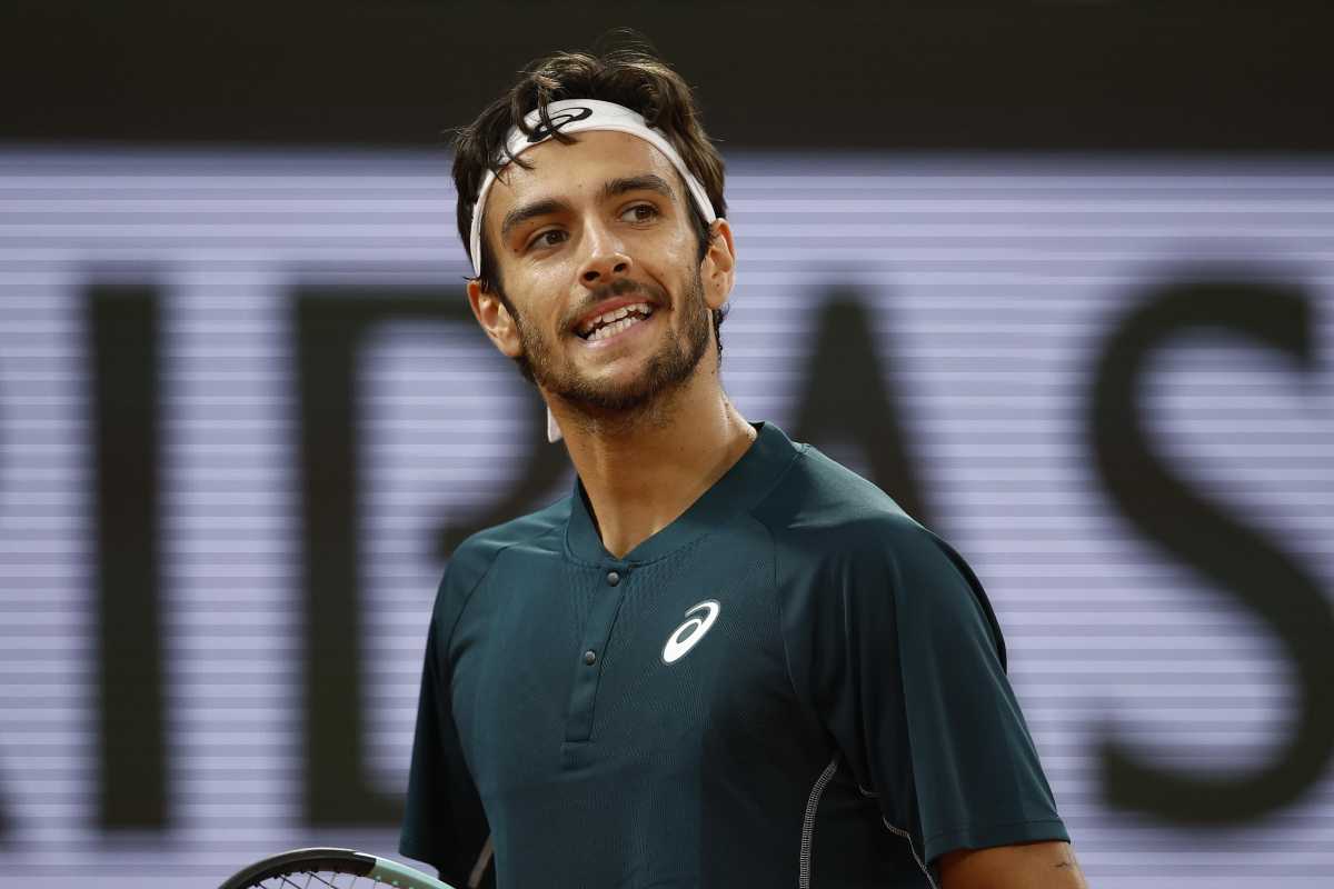 Lorenzo Musetti sorride amaro in campo al Roland Garros