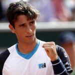 Primo piano di Matteo Gigante che alza il pugno dopo la vittoria al Roland Garros