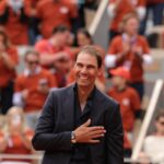 Rafael Nadal vestito in abito elegante si porta la mano al petto per ringraziare il Philippe Chatrier