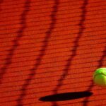 Pallina da tennis che rimbalza sulla terra rossa