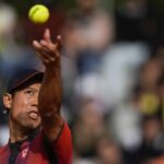 Kei Nishikori si appresta a servire alzandosi la palla