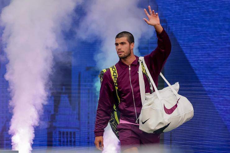 Carlos Alcaraz saluta il pubblico con la mano all'ingresso in campo