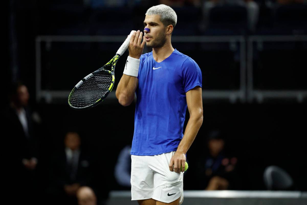 Carlos Alcaraz si soffia sulle dita durante un match