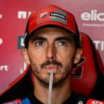 Bagnaia che beve con espressione seriosa