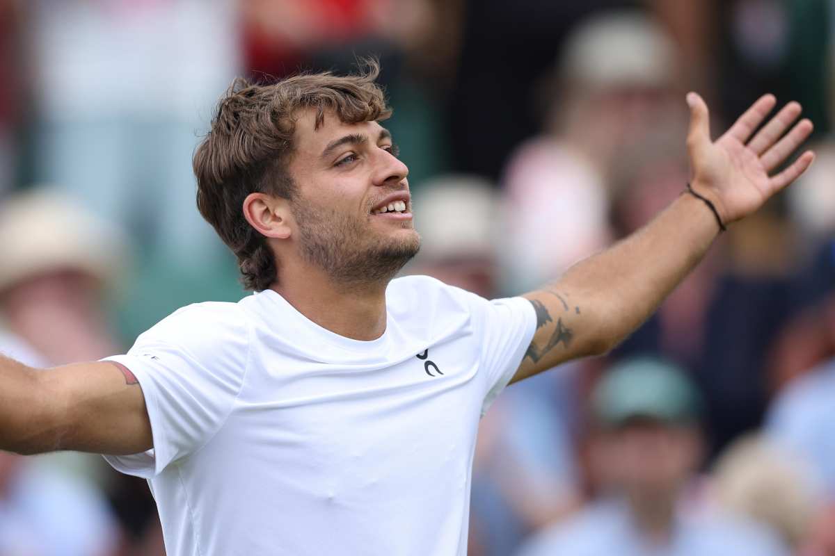 Cobolli esulta alzando le braccia al cielo