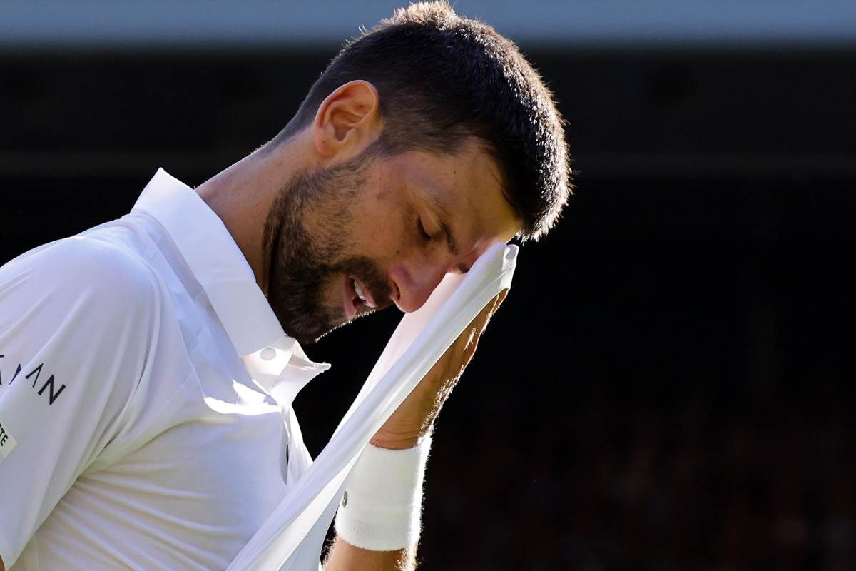 Novak Djokovic si asciuga la fronte con la maglietta 