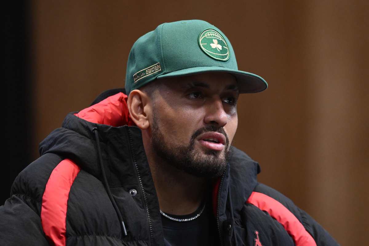 Nick Kyrgios in conferenza stampa con giubbotto nero e cappello verde