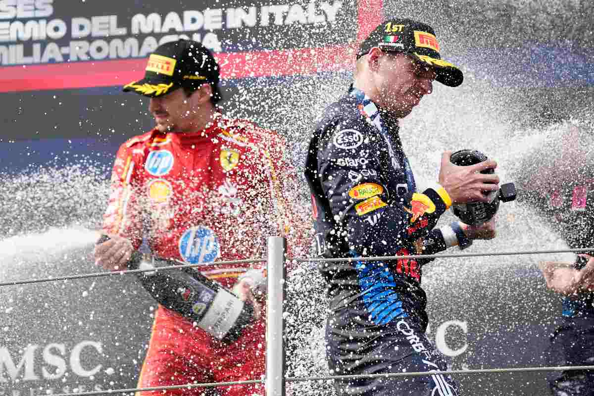 Leclerc e Verstappen festeggiano sul podio spruzzando champagne