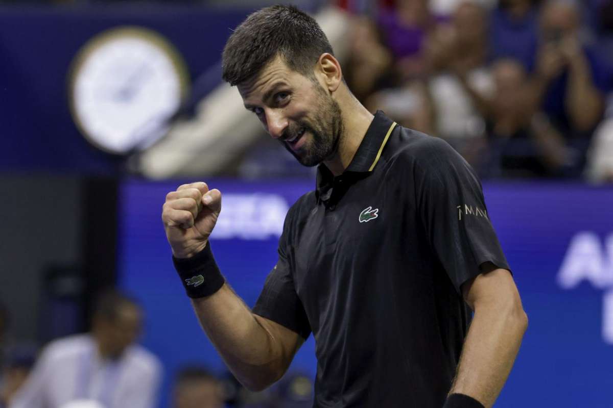 Novak Djokovic di profilo, sorridente e mentre stringe il pugno