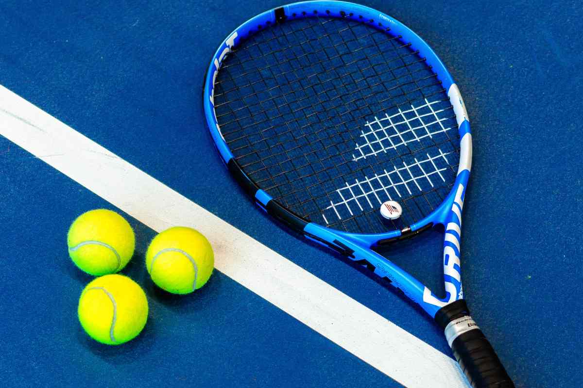 Racchetta e palline da tennis su un campo in cemento