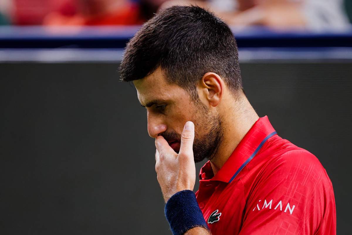 Djokovic si porta la mano alla bocca con espressione pensierosa