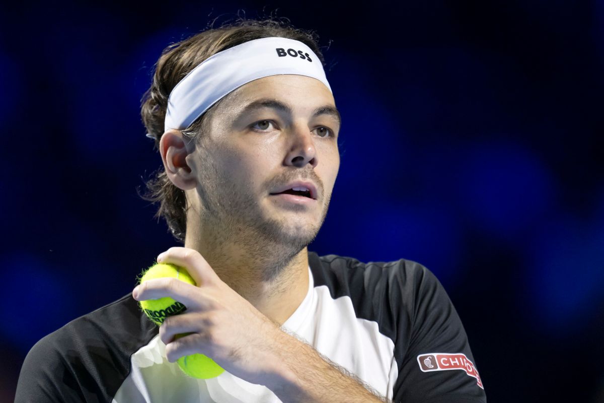 Primo piano di Taylor Fritz che si appresta a servire tenendo in mano due palline da tennis