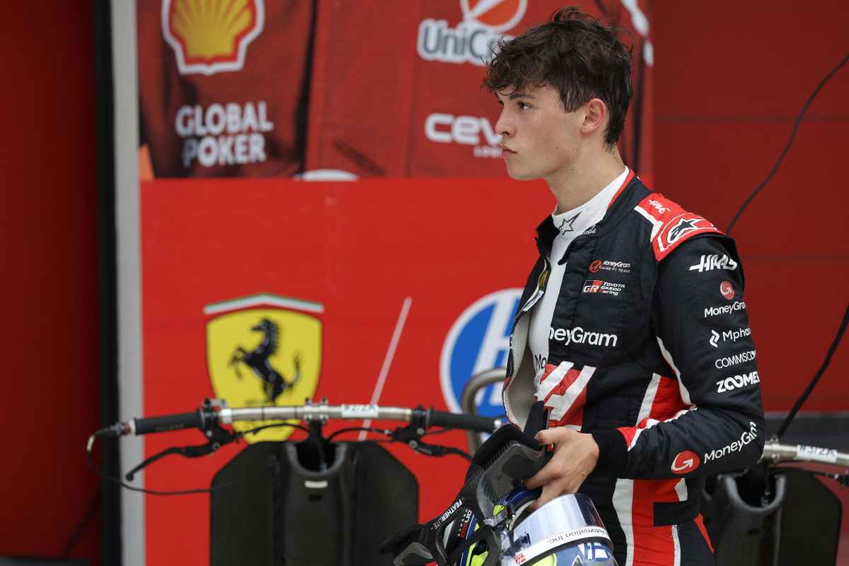Oliver Bearman staziona presso il box Ferrari indossando la tuta della Haas