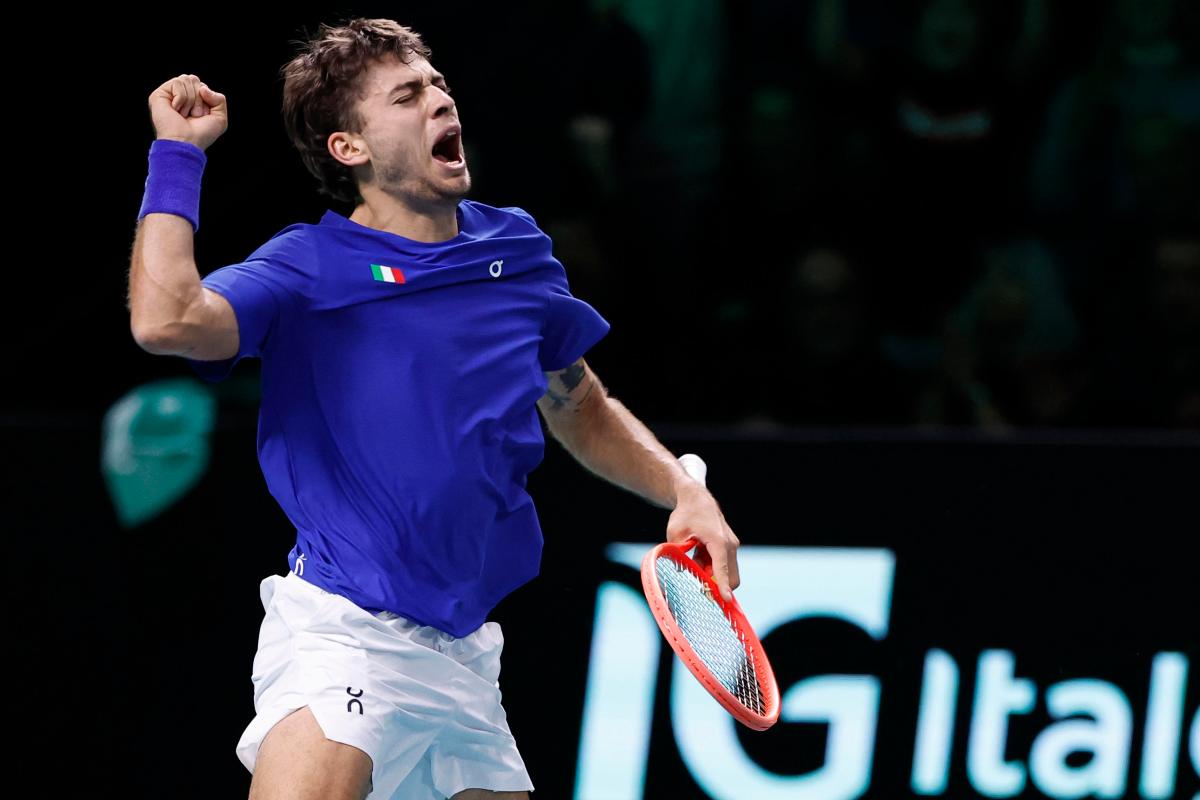 Flavio Cobolli esulta saltando, urlando ed alzando il pungo a cielo dopo una vittoria in Coppa Davis con la maglia azzurra dell'Italia