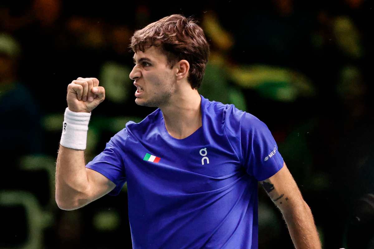 Cobolli esulta alzando il pugno durante una partita di Coppa Davis con la maglia dell'Italia