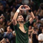 Djokovic, con la maglietta strappata, fa il segno del cuore con le mani festeggiando il trionfo ad Atene