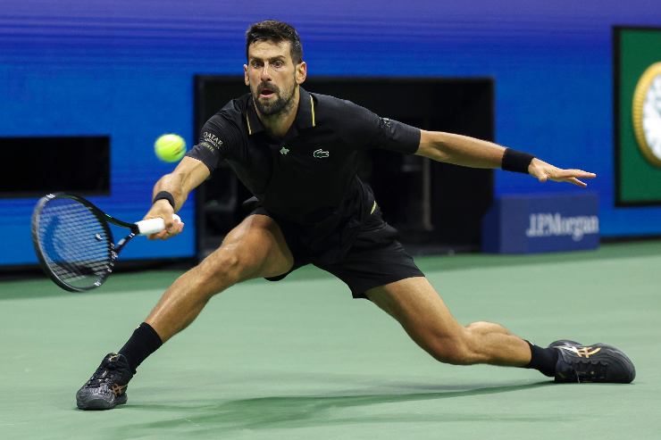 Novak Djokovic recupera palla con una scivolata