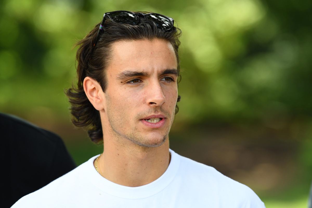 Primo piano di Lorenzo Musetti con maglietta bianca ed occhiali da sole tra i capelli