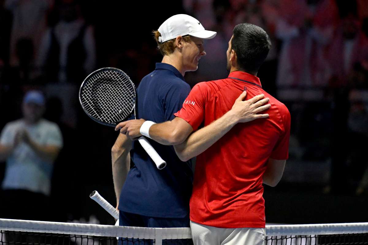Sinner e Djokovic si abbracciano sorridenti a rete al termine di un match
