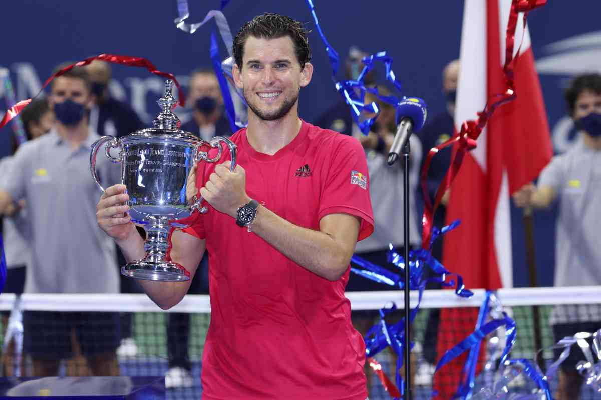 Dominic Thiem posa sorridente per una foto tenendo tra le mani il trofeo appena vinto allo US Open 2020
