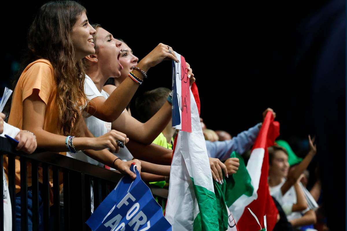 Tifose italiane esultano urlando e sventolando la bandiera tricolore