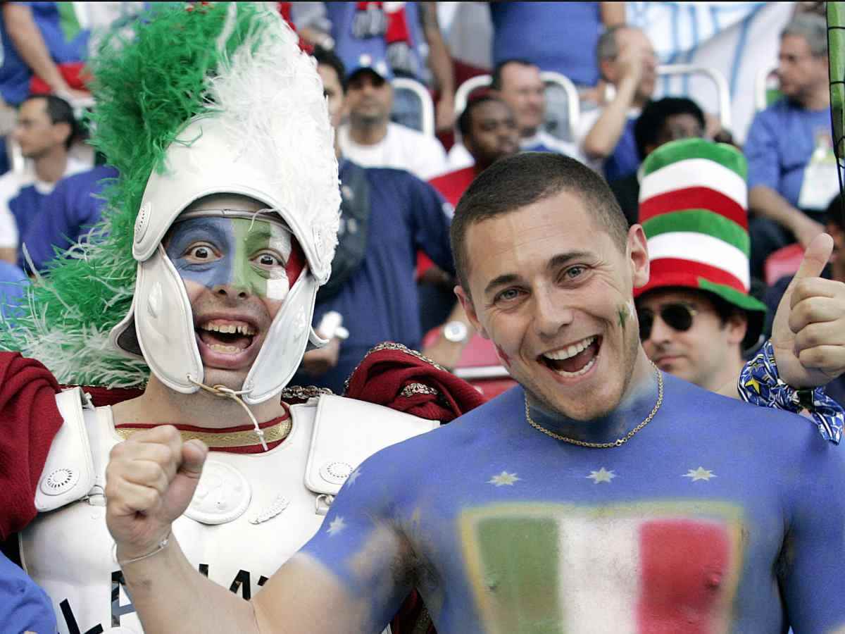 Tifosi italiani esultano sorridenti pittati di tricolore